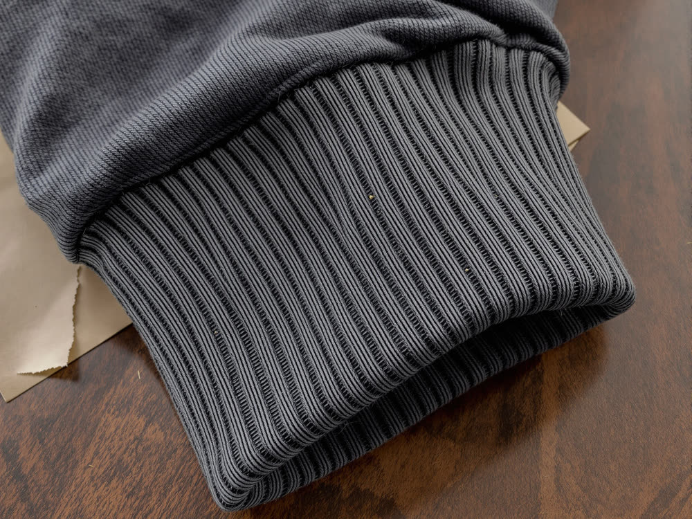 Macro of a ribbed cotton cuff showing individual fibres and knit loops.